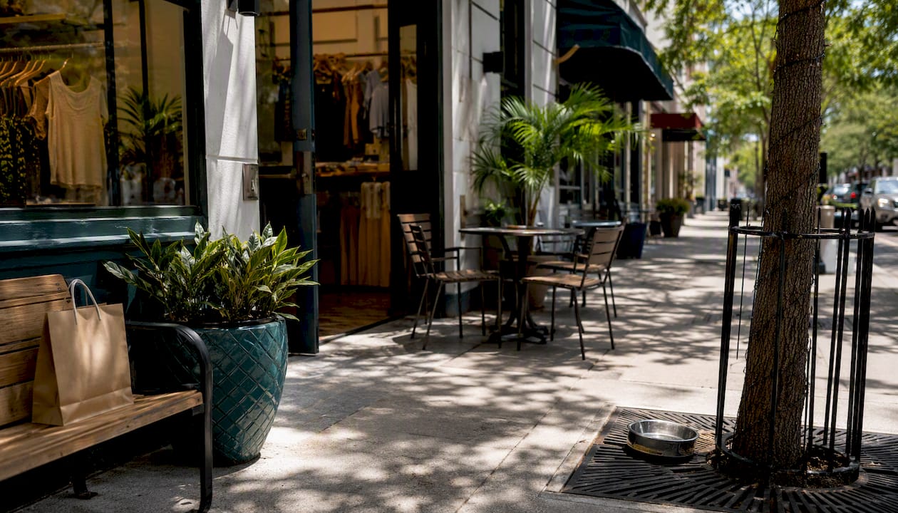 Active street-level retail sidewalk with pet bowl and bench
